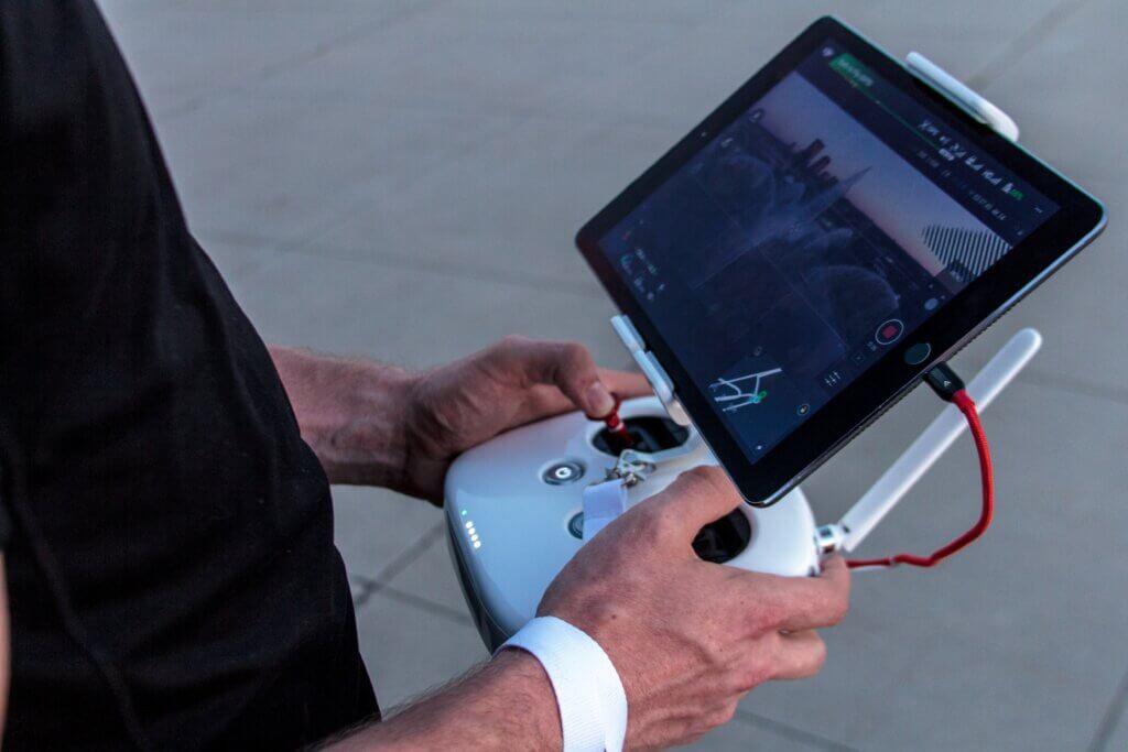 A man controlling a drone with iPad